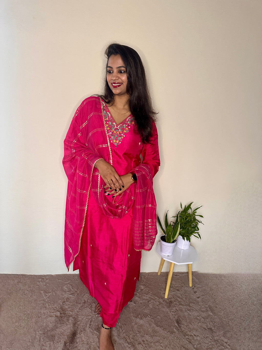 Woman wearing a pink dola silk salwar suit with hand embroidered neckline and matching dupatta