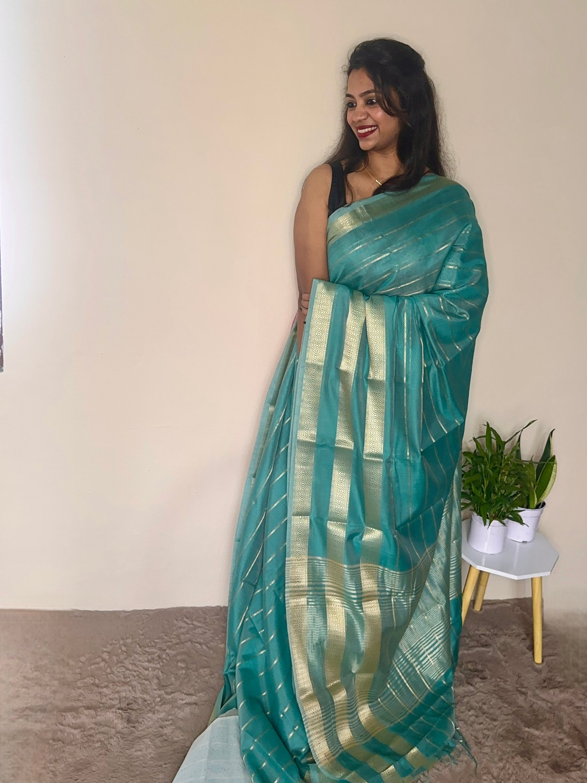 Model wearing a turquoise blue soft cotton saree with gold zari detailing, styled for festive wear – Jayithva