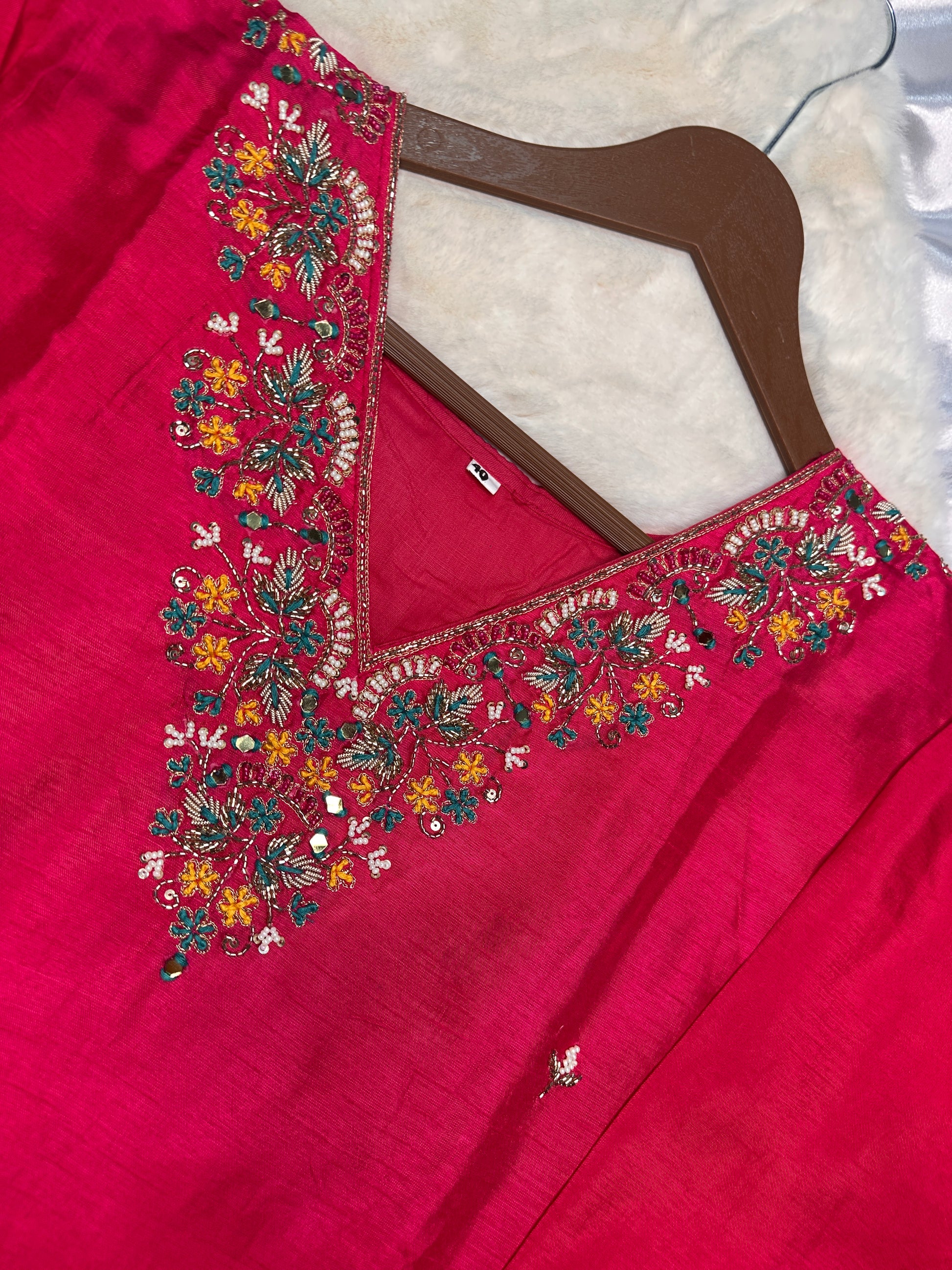 Close-up of hand embroidered neckline on pink dola silk kurta set