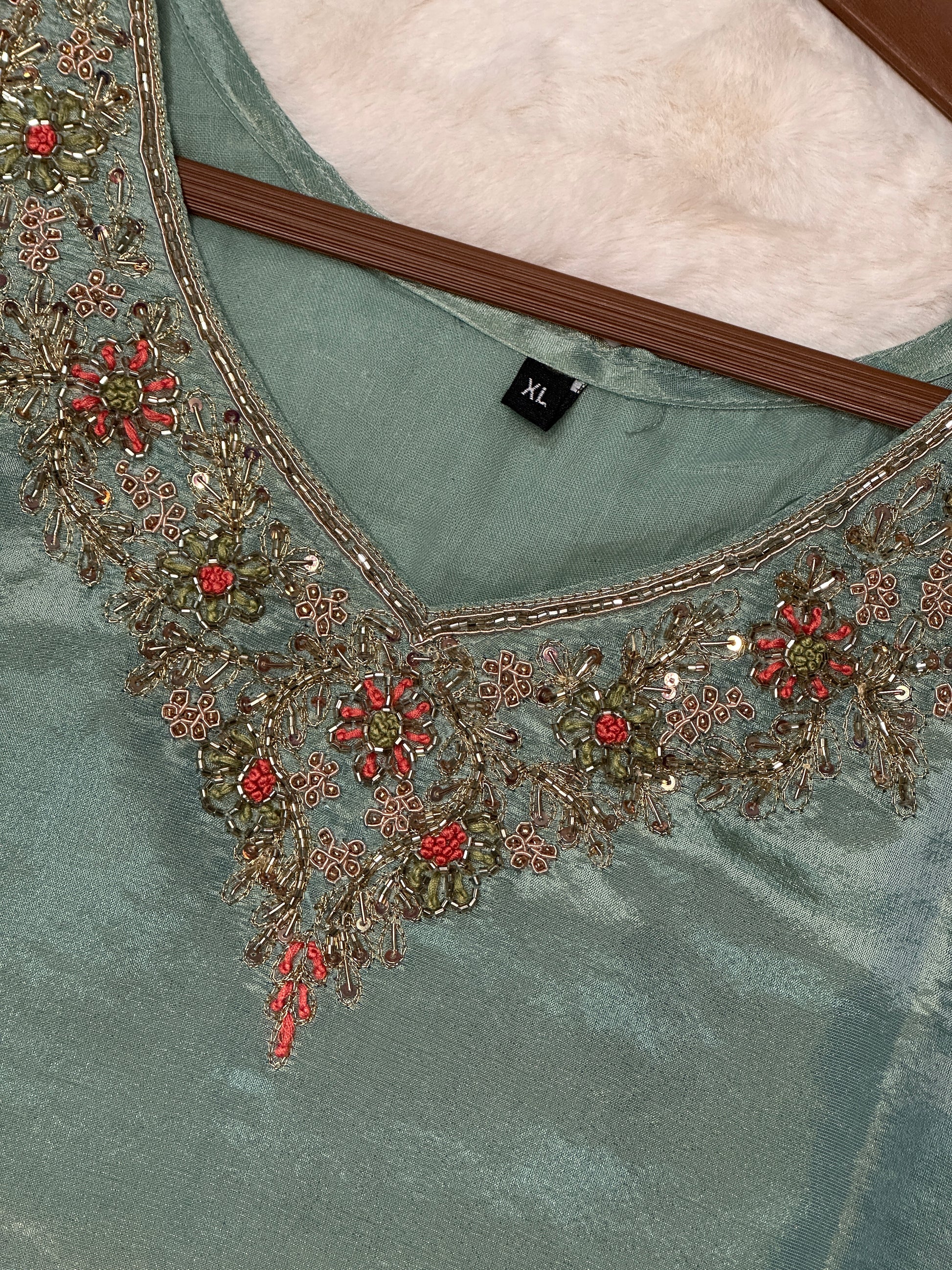 Close-up of embroidered neckline on green tissue silk kurta set